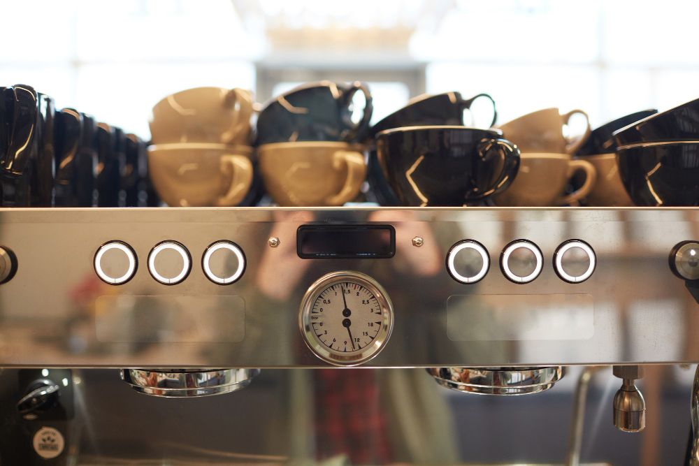 machine à café en acier dans un café avec des tasses assorties