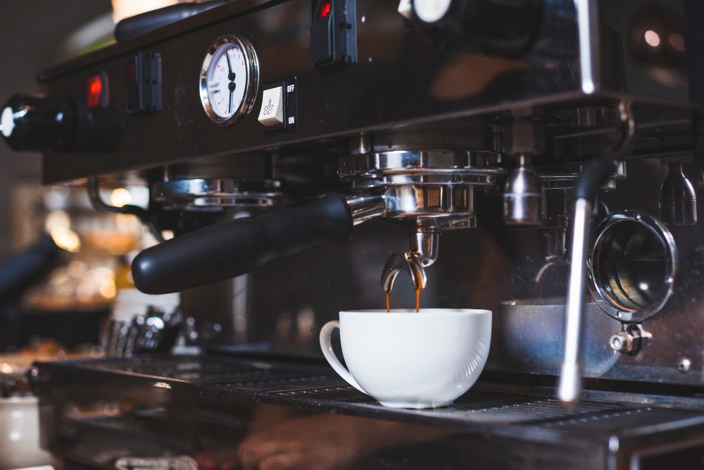 Machine à café versant du café frais dans une tasse blanche