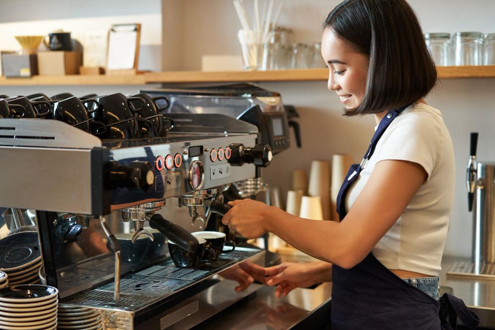 barista utilisant une machine à café pour préparer un cappuccino